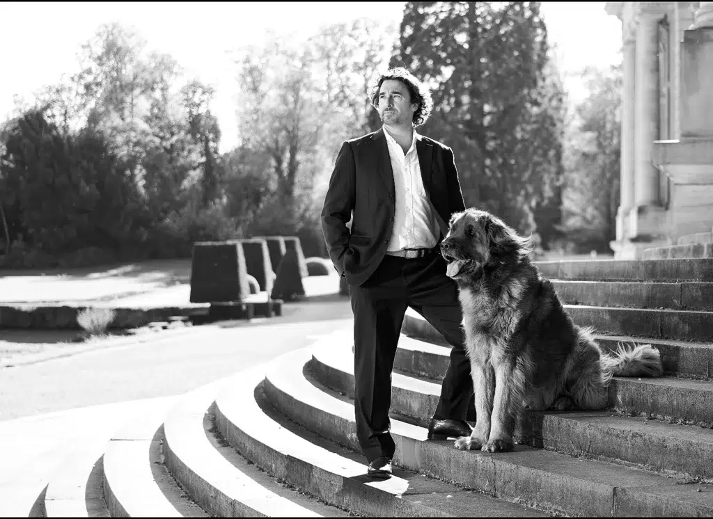 Man met Berner Sennenhond op trap – zwart-wit portretfotografie door Greycard Tervuren