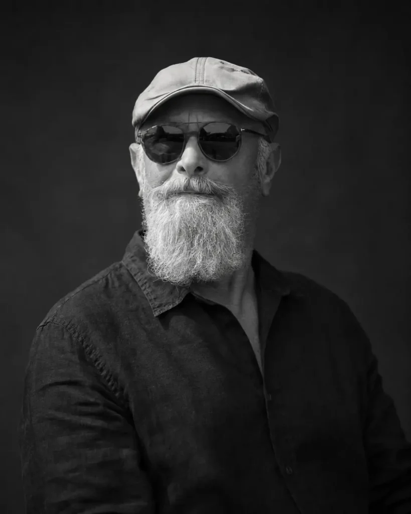 Zwart-witportret van een bebaarde man met pet en zonnebril – Greycard