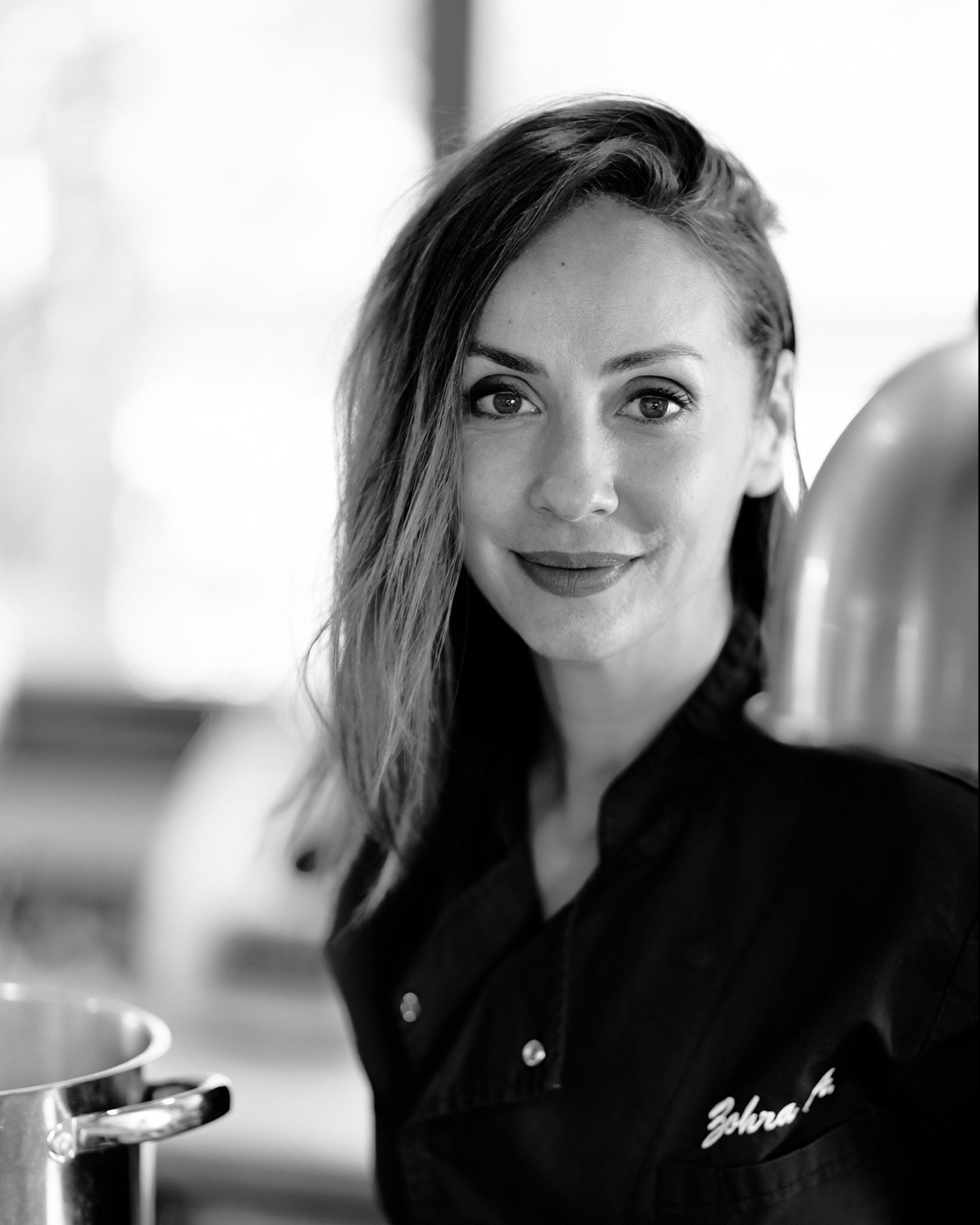 Portrait en noir et blanc de Zohra, cheffe dans sa cuisine